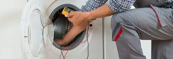 Dryer repair technician inspecting and repairing a clothes dryer in South Bend, IN