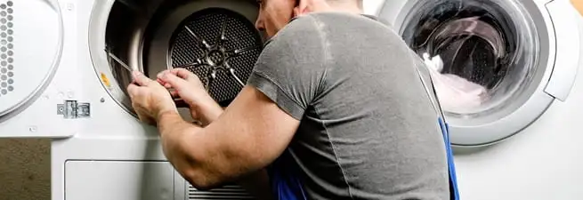 Dryer repair technician fixing a clothes dryer drum in South Bend, IN