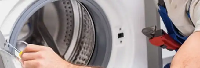 Appliance technician repairing a clothes dryer drum and internal parts in South Bend, IN