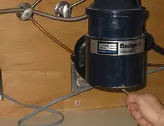 Garbage disposal repair technician tightening the mounting ring under a sink in South Bend, IN