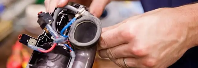 Vacuum repair technician reconnecting wiring and components in South Bend, IN
