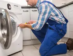 Washing machine repair technician servicing a front-load washer in South Bend, IN